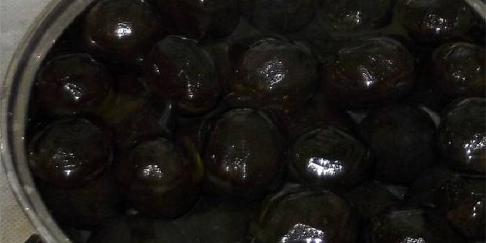 Nozes verdes jovens em uma panela com calda