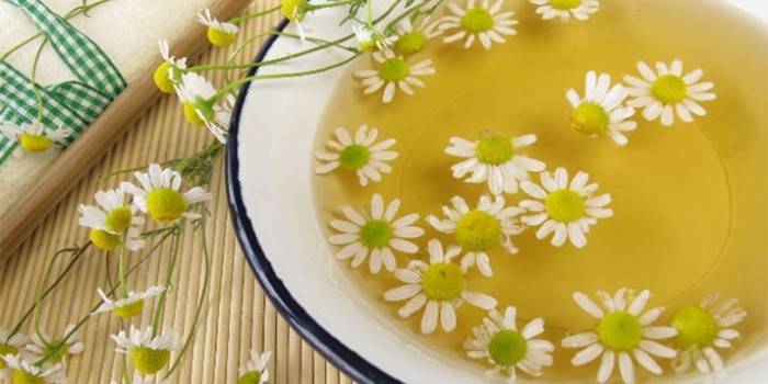 Lavabo con caldo y flores de manzanilla
