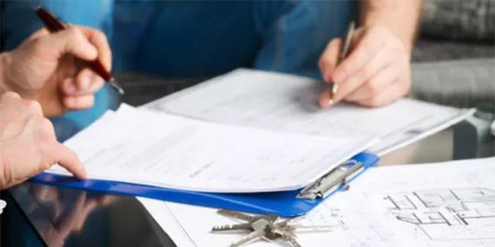La gente firma documentos