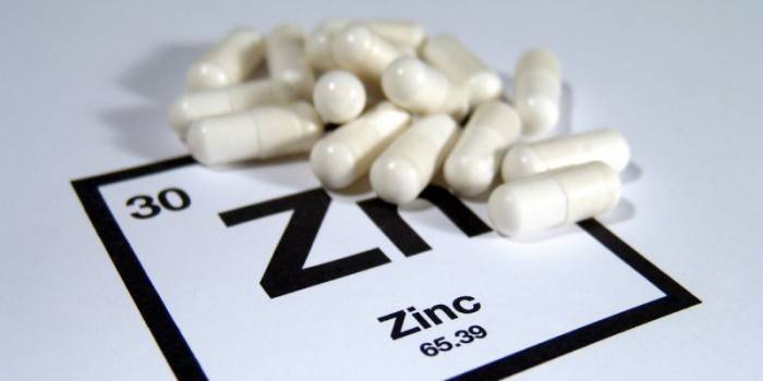 Cápsulas blancas y el icono de elemento de zinc.