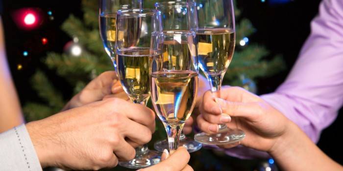 Las personas tintinean copas con champán