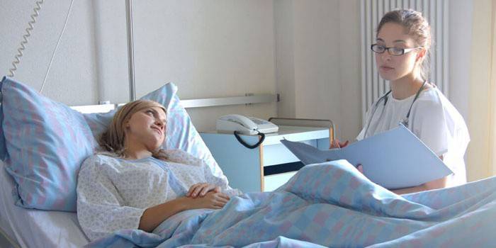 Niña en una sala de hospital habla con un médico