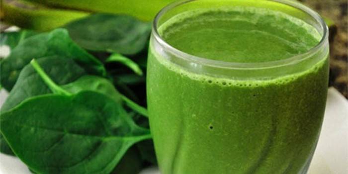 Un vaso de jugo de espinacas y hojas.