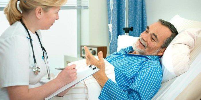 Un hombre en una sala de hospital habla con un médico.