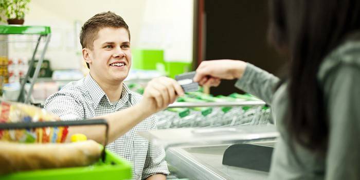 Chica paga con tarjeta de crédito en supermercado
