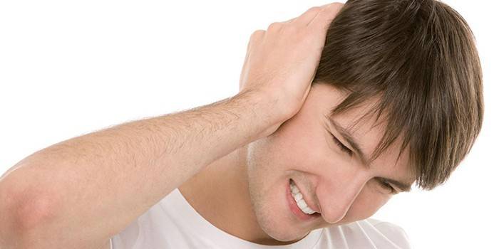 El hombre sostiene la mano por la oreja