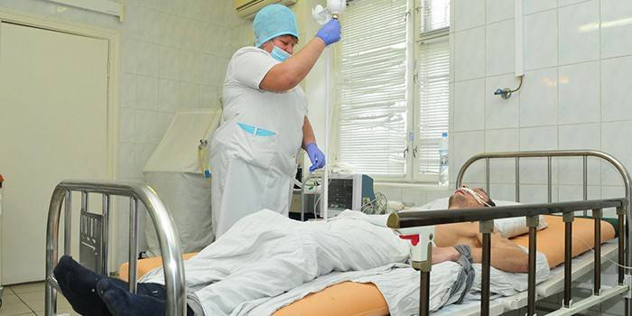 Sanitariusz stawia mężczyznę kroplomierzem