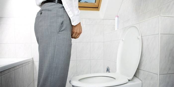 Um homem fica perto do banheiro