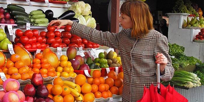 Dievča si vyberie zeleninu na trhu