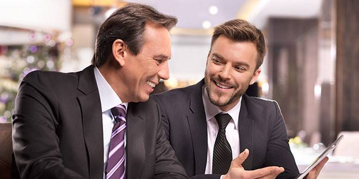 Los hombres están mirando la tableta.