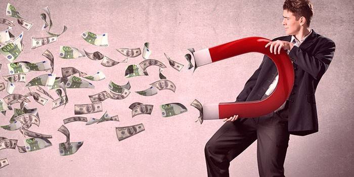 Un hombre atrae dinero con un imán.