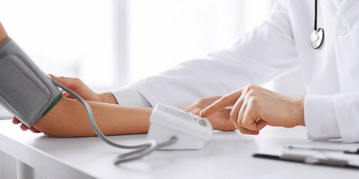 El médico mide la presión del paciente.