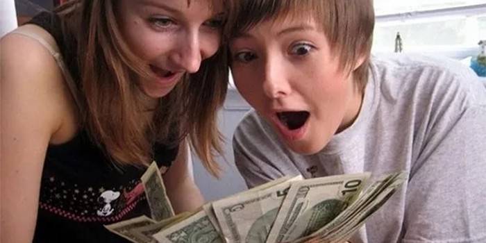 Adolescentes com notas de dólar em suas mãos
