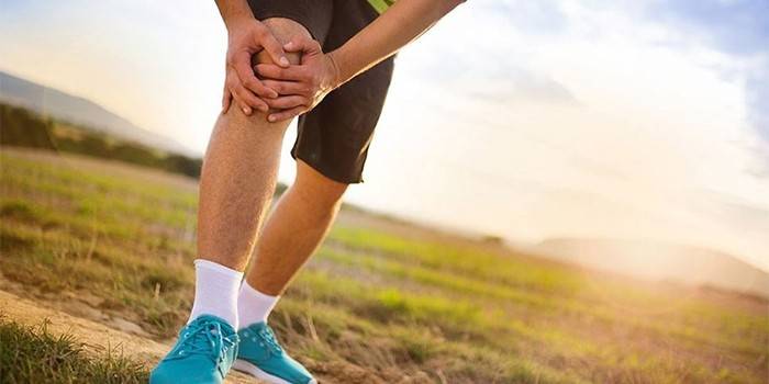 Um homem em uma corrida mantém as mãos no joelho