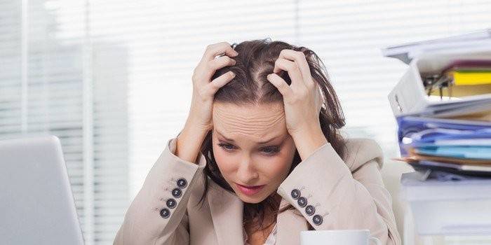 La niña en el lugar de trabajo tiene las manos detrás de la cabeza.