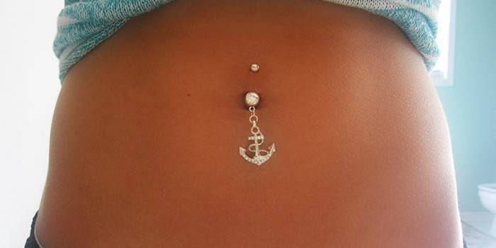 A menina tem um piercing no umbigo
