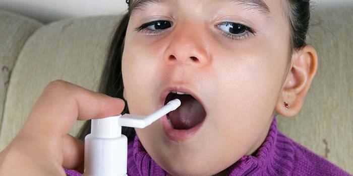 Uma menina é pulverizada na cavidade oral