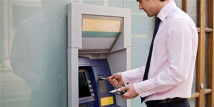 Mężczyzna w pobliżu bankomatu