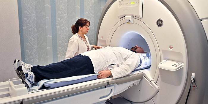 Un hombre en una máquina de resonancia magnética y un médico.