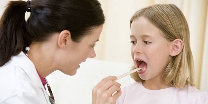 El médico examina la garganta de un niño.