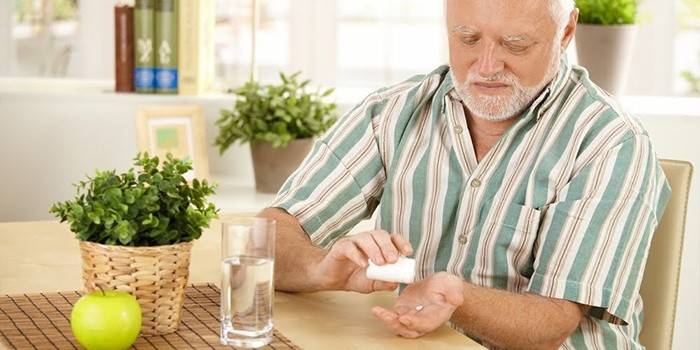 Un hombre se prepara para tomar una pastilla.