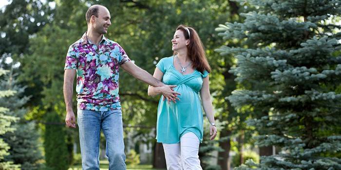 Mujer embarazada con marido a pasear por el parque