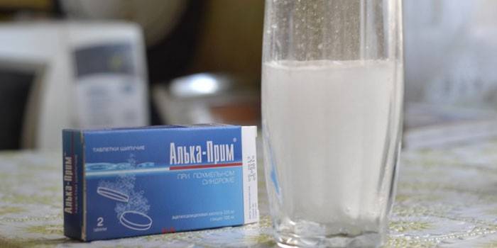 Alka-Prim y un vaso con una tableta disuelta en agua