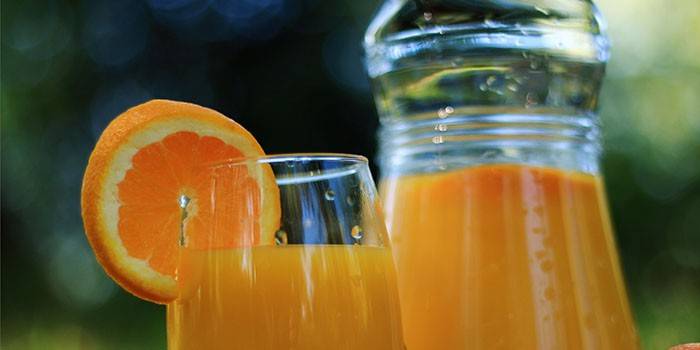 Jarra y vaso con jugo de naranja