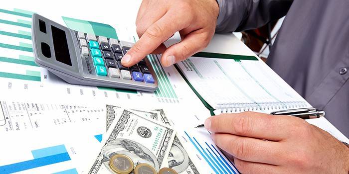 El hombre hace cálculos usando una calculadora.