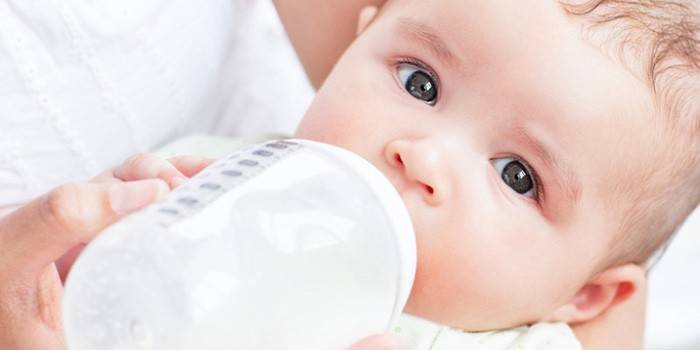 Bebê come uma mistura de uma garrafa
