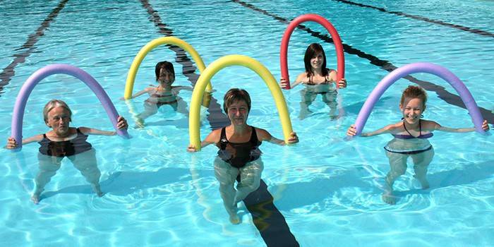 Cinco mujeres con fideos en la piscina