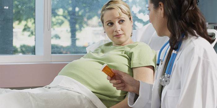 O médico dá uma mulher grávida um pote de comprimidos