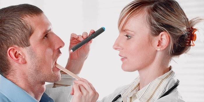 El médico examina la garganta del paciente.