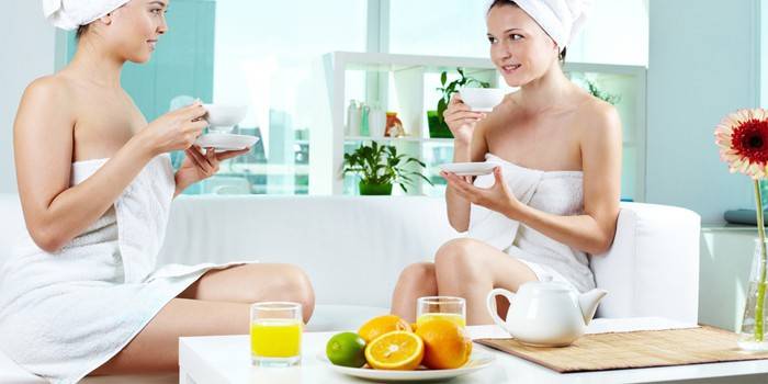 Duas garotas bebem chá e suco no spa