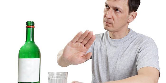 Um homem recusa uma garrafa de álcool