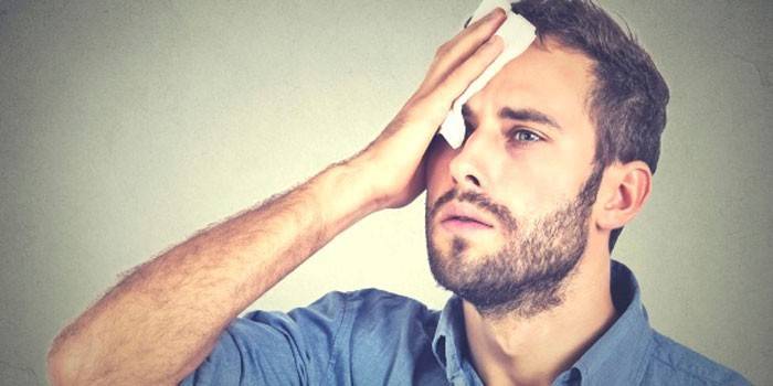 Um homem colocou um lenço na testa.