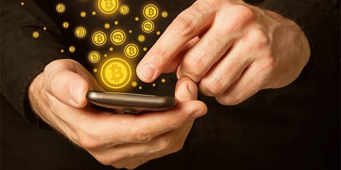 Mężczyzna z ikonami smartphone i bitcoin.