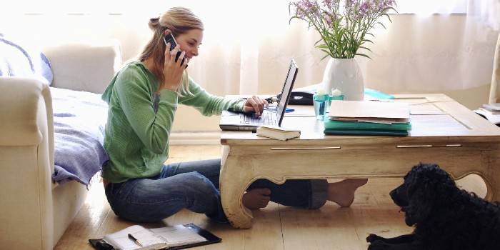 A garota no laptop fala ao telefone