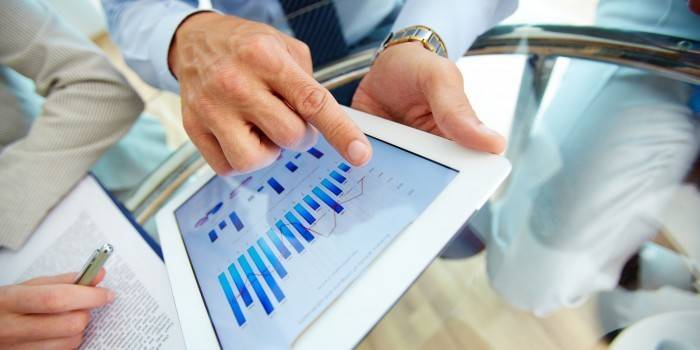 Tablet com gráficos nas mãos de um homem