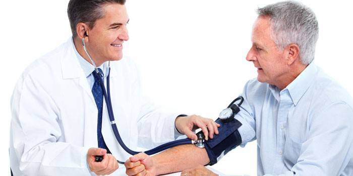 El médico mide la presión de un anciano.