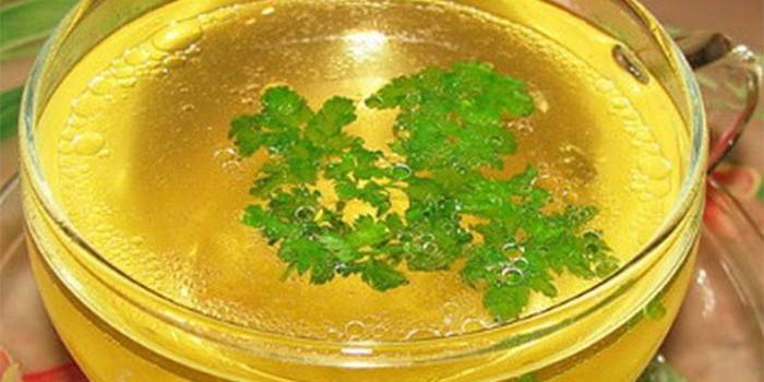 Caldo de galinha leve com salsa em um copo