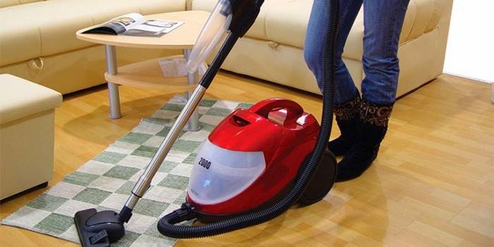 Menina limpando o chão em um apartamento