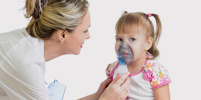 El médico sostiene una máscara de oxígeno en la cara del niño.