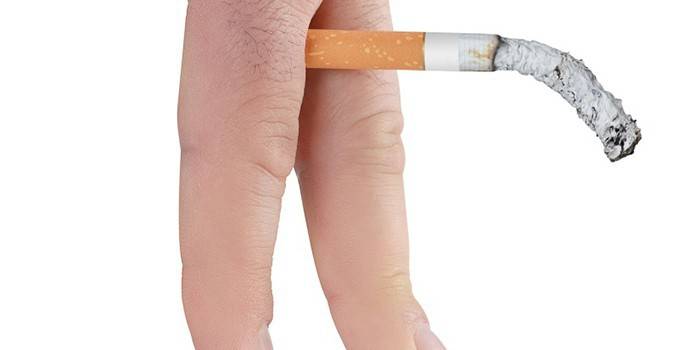 Doutnajúca cigareta medzi prstami