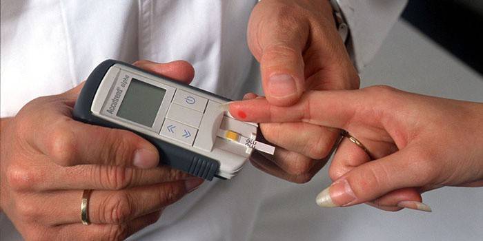 O médico mede o nível de açúcar no sangue do paciente com um glicosímetro