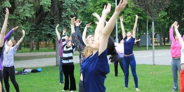 Pessoas fazendo exercícios de respiração ao ar livre.
