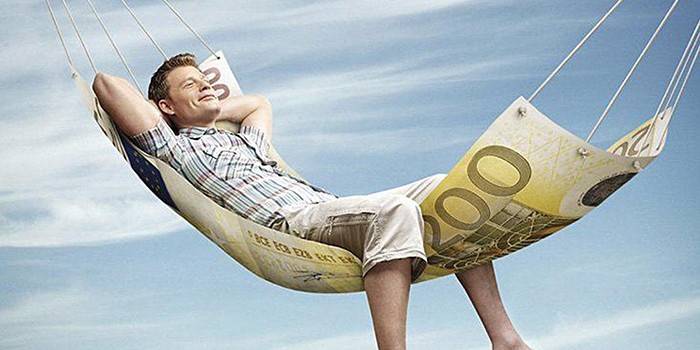 Mężczyzna leży w hamaku z banknotu 100 euro