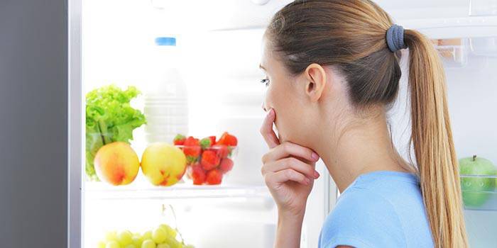 Niña elige comida en el refrigerador