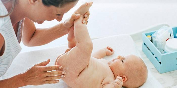 La mujer aplica ungüento a la piel del bebé.