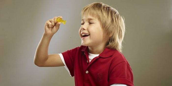 A criança segura um peixe em suas mãos